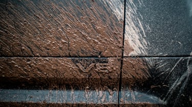 Land Rover Defender 130 P500 AWD - muddied V8 badge